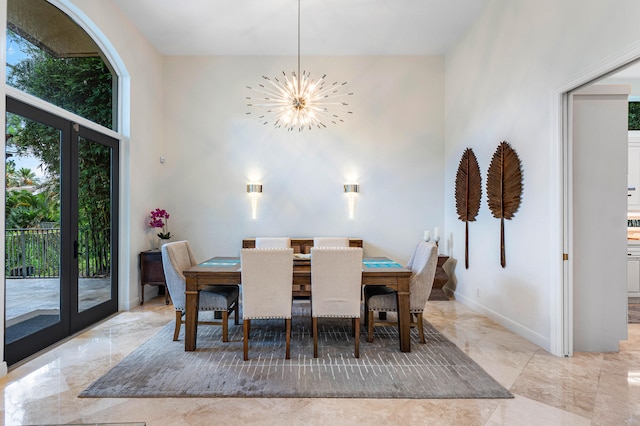 dining area featuring a high ceiling, a wealth of natural light, and an inviting chandelier