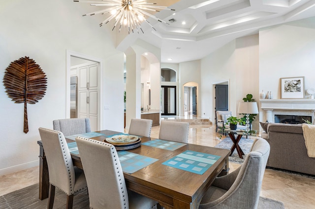 dining area featuring coffered ceiling, a towering ceiling, and a chandelier