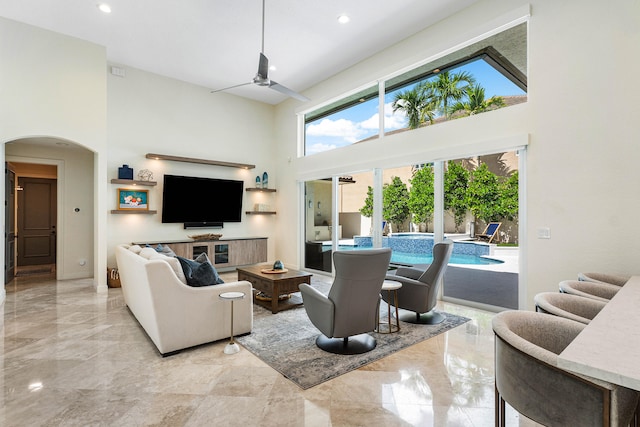 living room with a high ceiling and ceiling fan