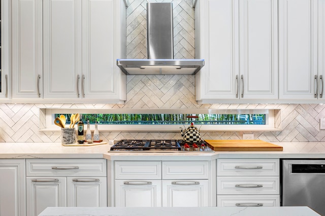 kitchen with appliances with stainless steel finishes, wall chimney exhaust hood, decorative backsplash, and white cabinetry