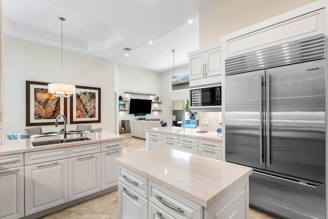 kitchen featuring sink, built in appliances, white cabinetry, and tasteful backsplash