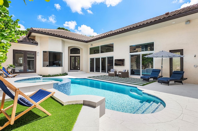 back of house featuring a patio area and a pool with hot tub