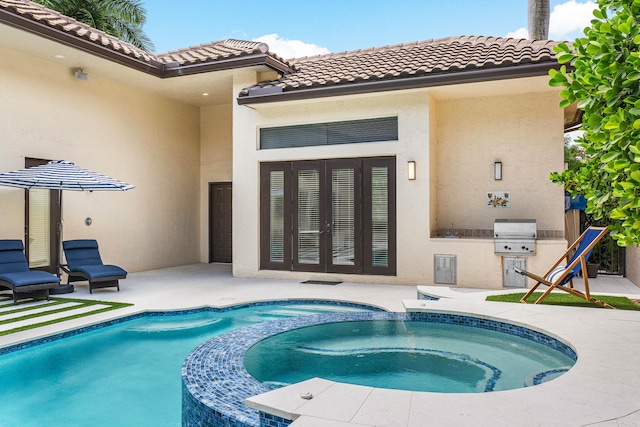 rear view of house with a patio area and a swimming pool with hot tub