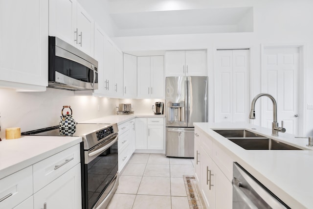 kitchen featuring stainless steel appliances, white cabinetry, and sink