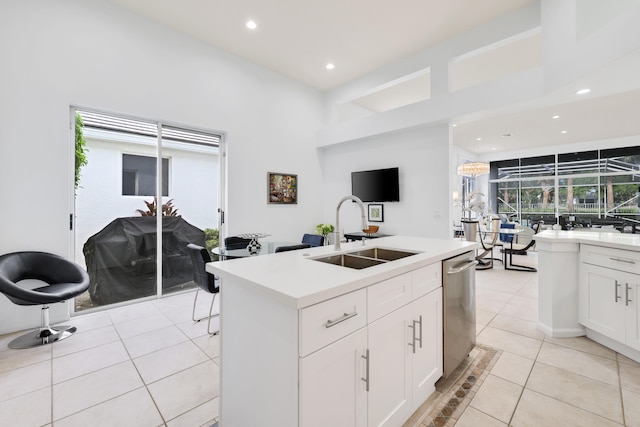 kitchen with dishwasher, a center island with sink, white cabinetry, and sink