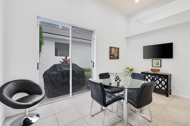 dining space with beamed ceiling and light tile patterned flooring