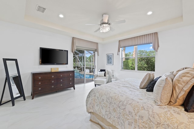 bedroom featuring a tray ceiling, ceiling fan, and access to outside