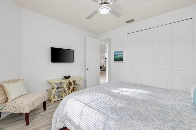 bedroom with a closet, ceiling fan, and light hardwood / wood-style flooring