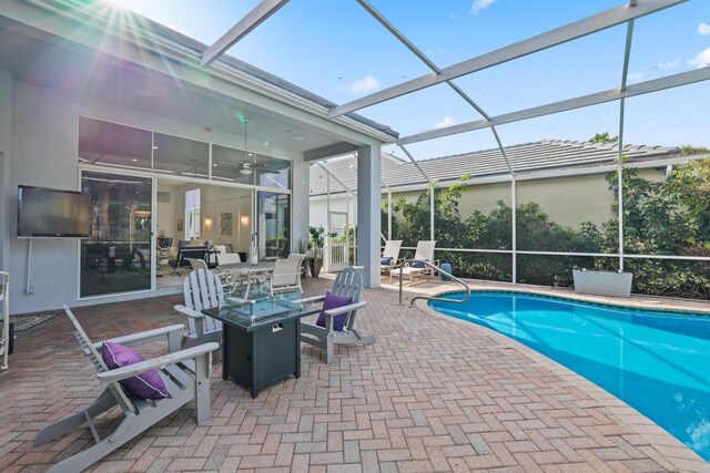 view of pool with a lanai, ceiling fan, and a patio