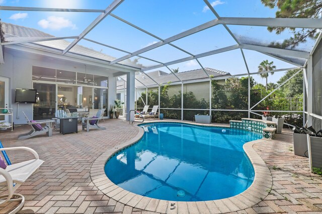 view of pool featuring glass enclosure and a patio area