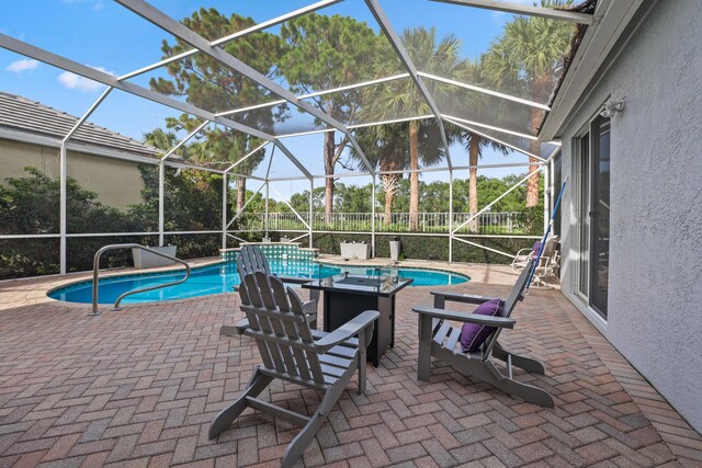 view of pool featuring glass enclosure and a patio