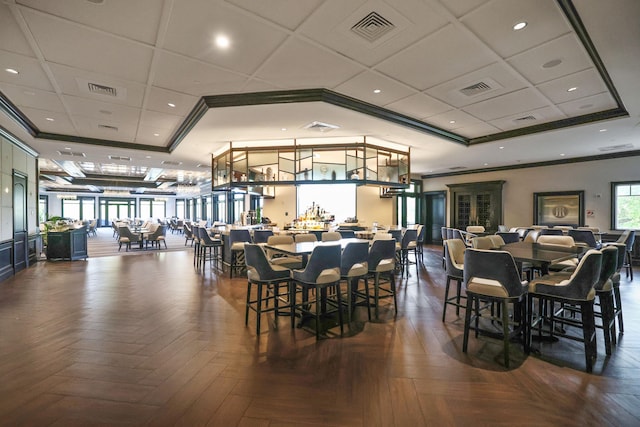 dining space featuring crown molding, dark parquet floors, and a tray ceiling