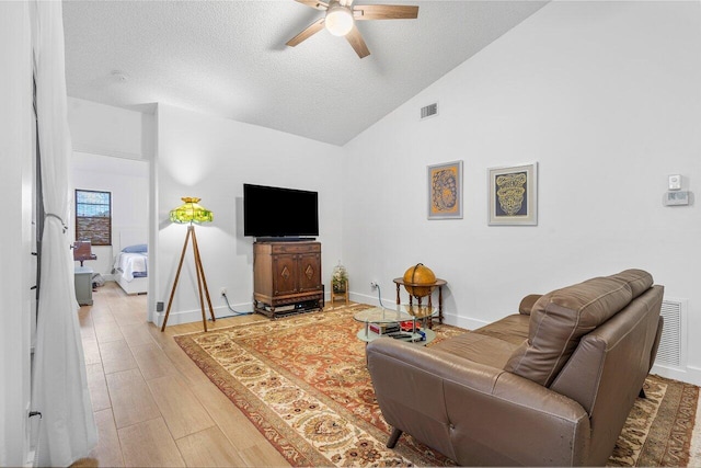 living room featuring ceiling fan, wood-type flooring, a textured ceiling, and high vaulted ceiling