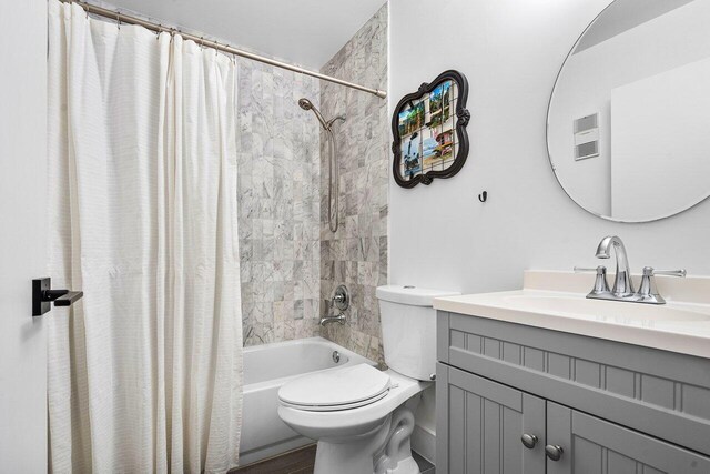 full bathroom with shower / bath combination with curtain, toilet, and vanity