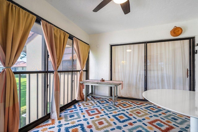 interior space with ceiling fan and a textured ceiling