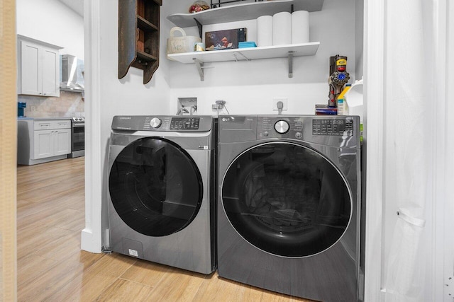 washroom featuring washer and dryer and light hardwood / wood-style floors