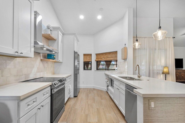 6055 Parkwalk Dr, Boynton Beach, FL 33472 - kitchen with appliances with stainless steel finishes, wall chimney range hood, a sink, a peninsula, and light countertops