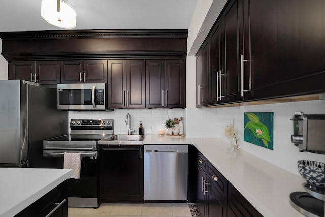 kitchen with backsplash, sink, dark brown cabinets, light tile patterned flooring, and stainless steel appliances