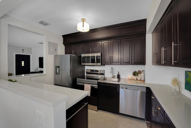 1305 NE 1st Ave, Fort Lauderdale, FL 33304 - kitchen featuring stainless steel appliances, light countertops, backsplash, light tile patterned floors, and a sink