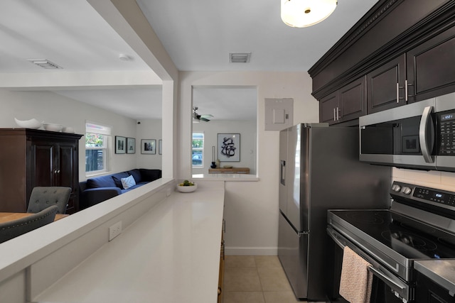 kitchen featuring dark brown cabinetry, ceiling fan, light tile patterned floors, and appliances with stainless steel finishes