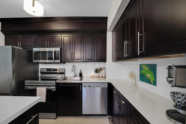 1305 NE 1st Ave, Fort Lauderdale, FL 33304 - kitchen featuring stainless steel appliances, a sink, light countertops, decorative backsplash, and light tile patterned flooring