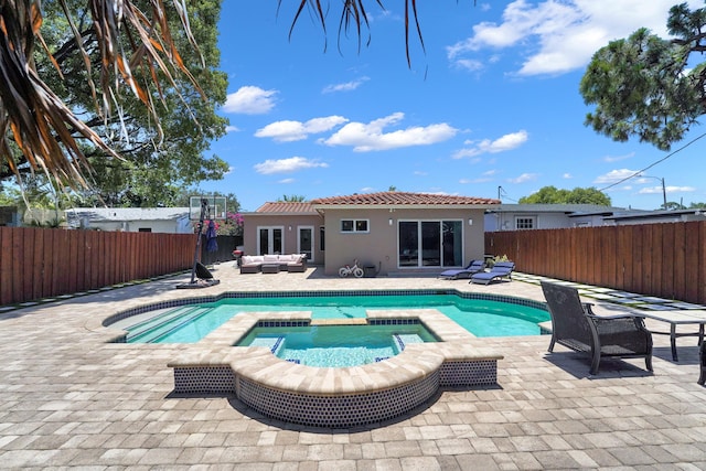 view of pool with an outdoor living space, a patio area, and an in ground hot tub