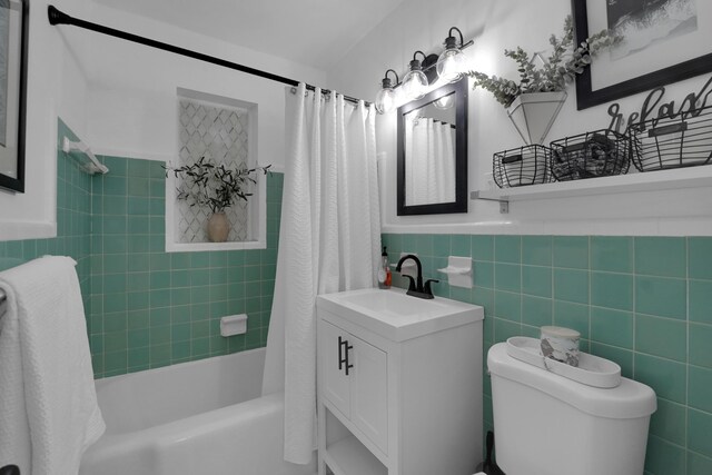 full bathroom with tile walls, vanity, shower / bath combo, and toilet