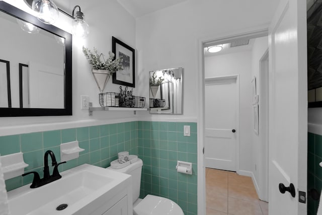 bathroom with tile patterned floors, vanity, toilet, and tile walls