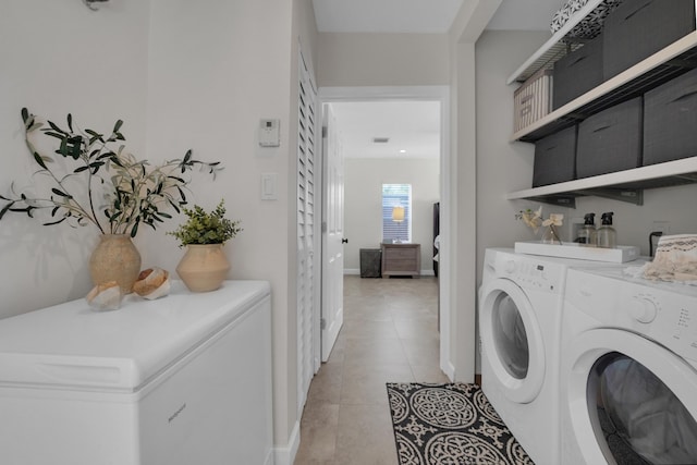 clothes washing area with washer and clothes dryer and light tile patterned floors