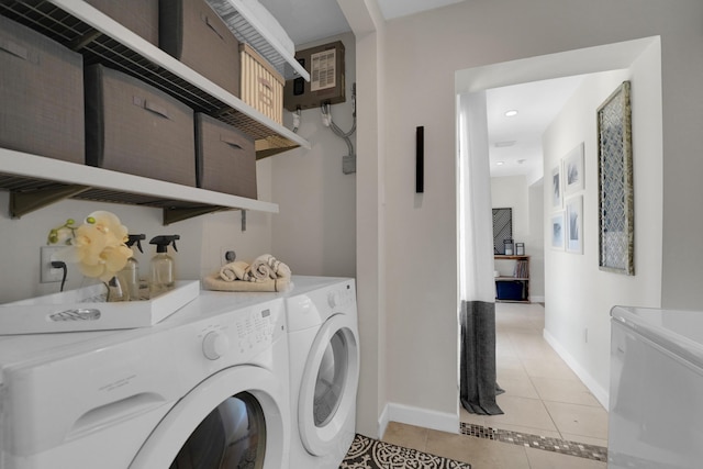 laundry area with washer and clothes dryer and light tile patterned floors