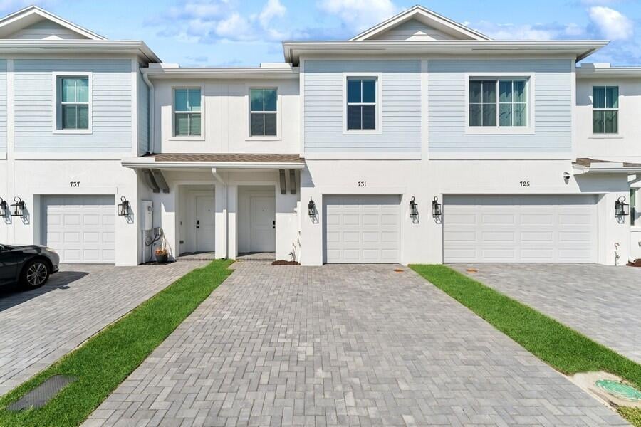 view of property with driveway, an attached garage, and stucco siding