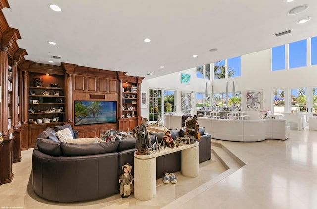 tiled living room featuring built in shelves and a towering ceiling