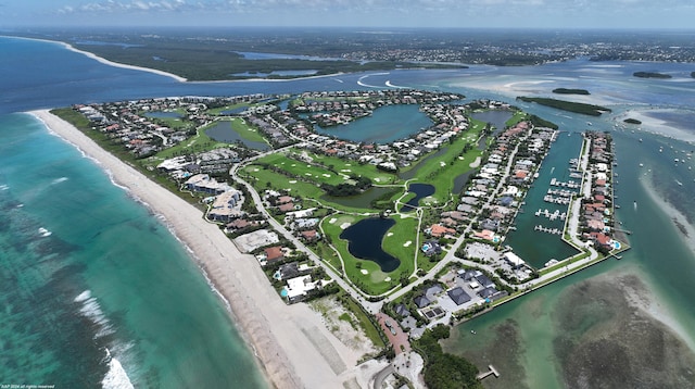 birds eye view of property with a water view and a beach view