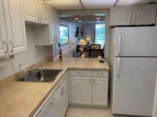 kitchen with sink, white fridge, and white cabinets