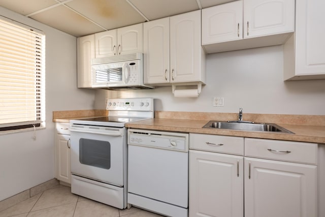 kitchen featuring light tile patterned flooring, sink, white cabinets, and white appliances