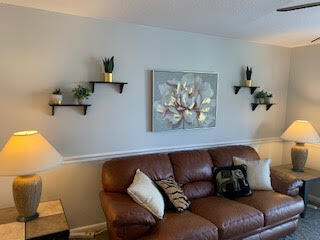 living room with ceiling fan and carpet