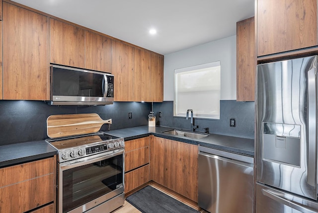 kitchen with appliances with stainless steel finishes, sink, and decorative backsplash