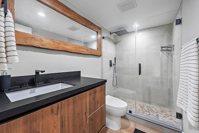 bathroom featuring toilet, a shower with door, wood-type flooring, and vanity