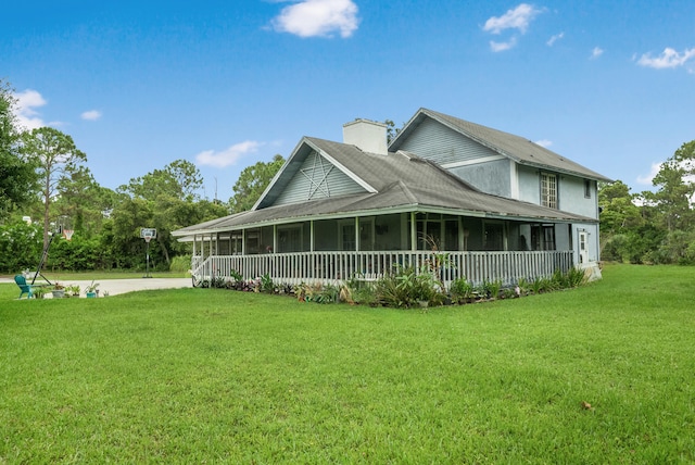 view of front facade with a front lawn and a sunroom