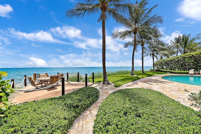 outdoor pool featuring a patio area and a water view