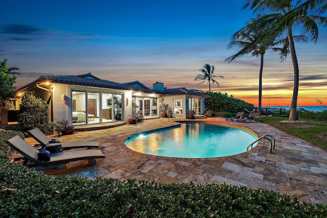 pool with french doors and a patio