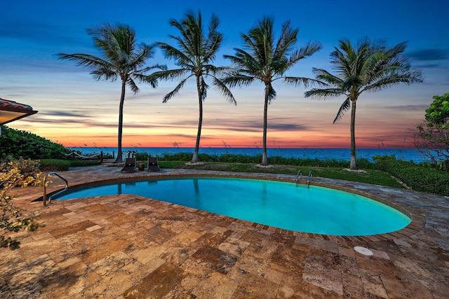 pool featuring a water view and a patio