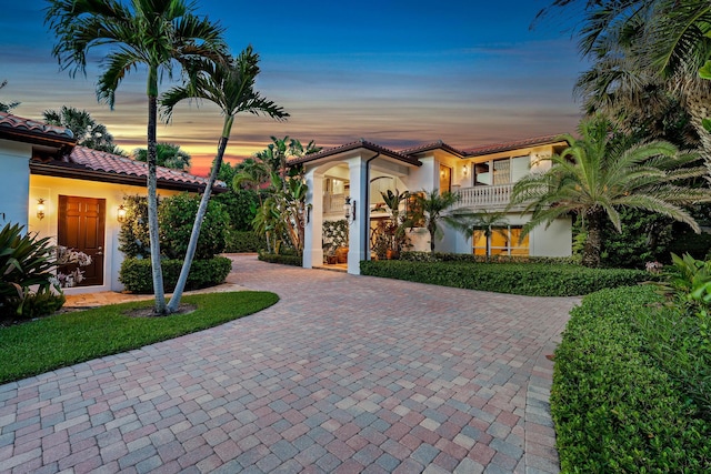 exterior entry at dusk with a balcony and french doors