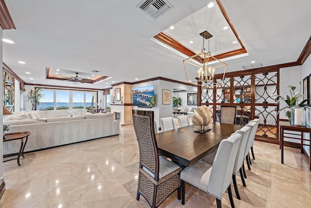 dining area with ceiling fan with notable chandelier, a raised ceiling, and crown molding