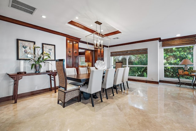 dining area featuring an inviting chandelier, ornamental molding, and a tray ceiling