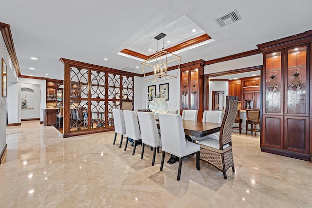 dining area featuring a raised ceiling, an inviting chandelier, and ornamental molding