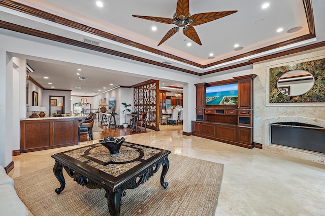 living room with ceiling fan, crown molding, and a high end fireplace