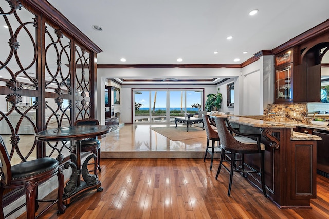 dining area with crown molding and dark wood-type flooring