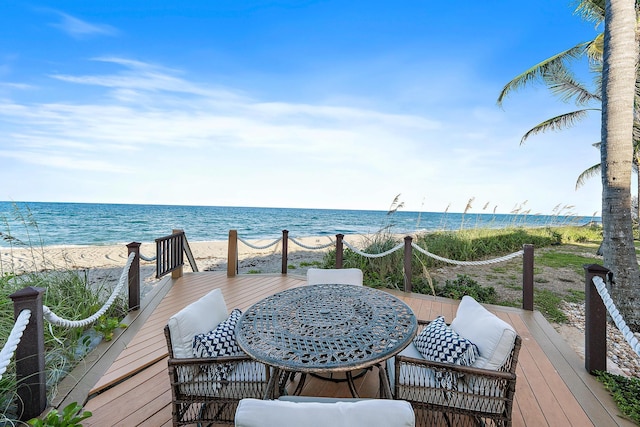 wooden terrace featuring a water view and a view of the beach