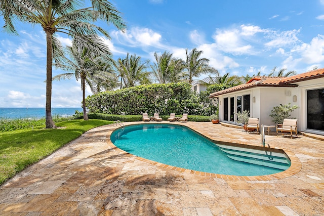 view of pool featuring a patio and a water view